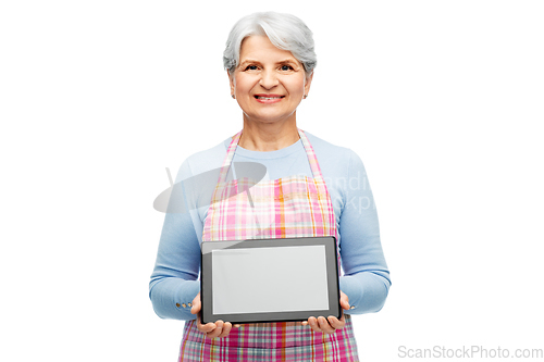 Image of smiling senior woman in apron with tablet computer