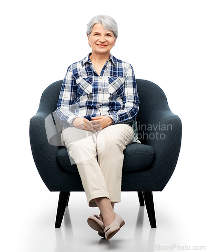 Image of smiling senior woman sitting in modern armchair