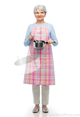 Image of senior woman in apron with pot cooking food