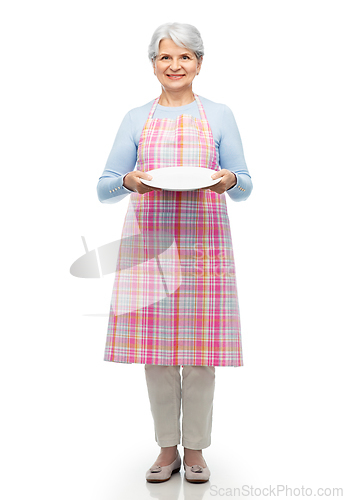 Image of smiling senior woman in apron with empty plate
