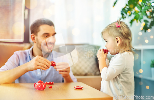 Image of father and daughter playing tea party at home