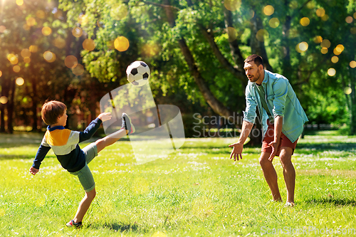 Image of father with little son playing soccer at park