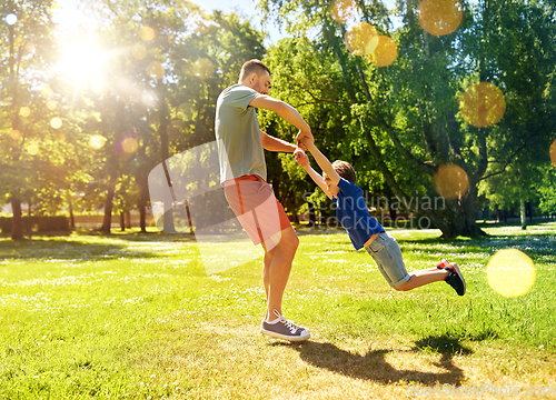 Image of happy father with son playing in summer park
