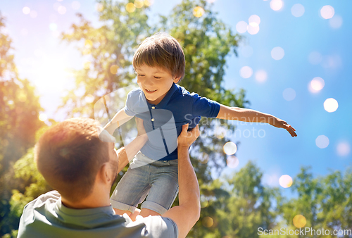 Image of happy father with son playing in summer park