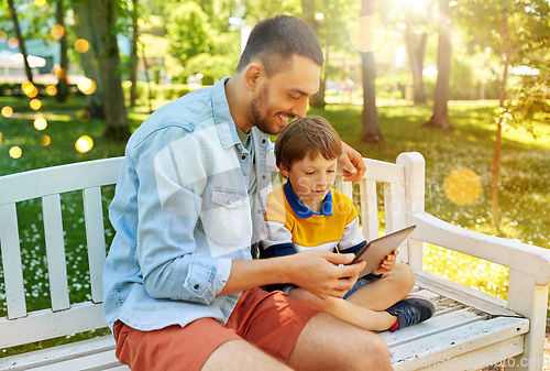 Image of father and son with tablet pc computer at park