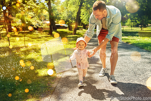 Image of happy father with baby daughter walking at park