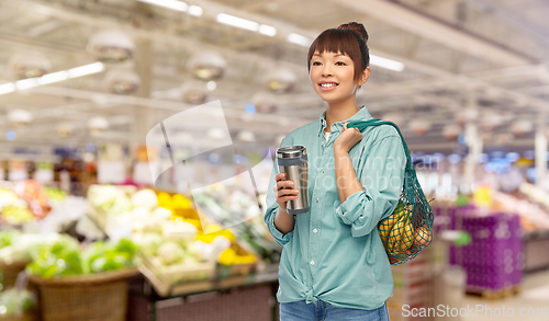 Image of woman with thermo cup or tumbler for hot drinks