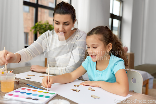 Image of happy mother with little daughter drawing at home