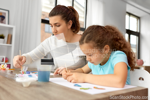 Image of mother with little daughter drawing at home