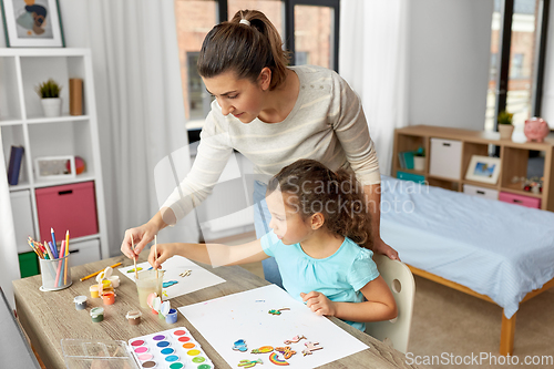 Image of mother with little daughter drawing at home