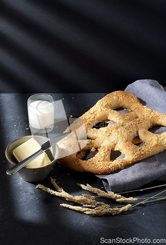 Image of close up of cheese bread, butter, knife and milk