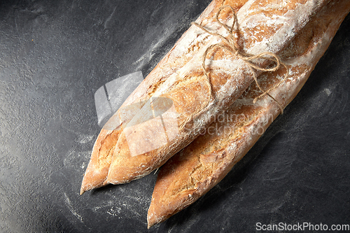 Image of pile of baguette bread loaves tied with rope