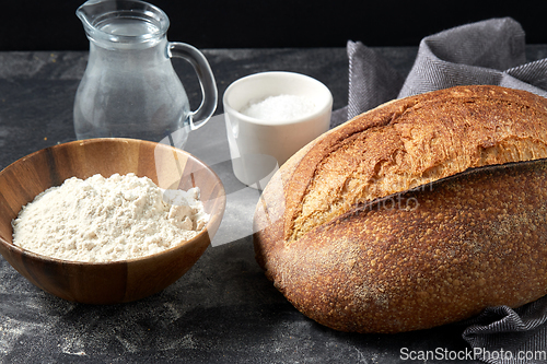 Image of bread, wheat flour, salt and water in glass jug