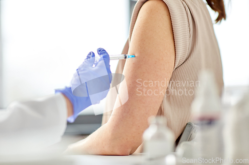 Image of close up of hand with syringe vaccinating patient