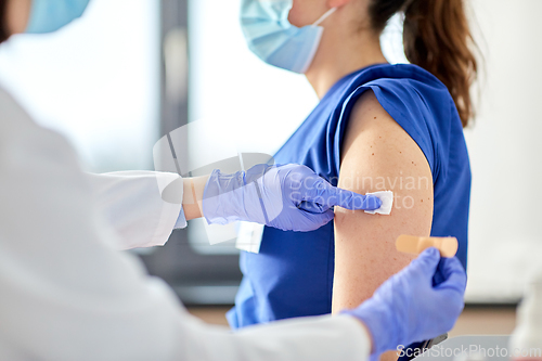 Image of doctor attaching patch to medical worker