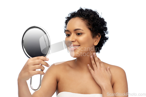 Image of smiling african american woman looking to mirror