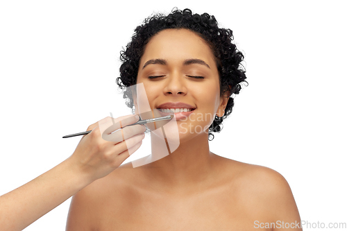 Image of happy woman and hand of make up artist with brush