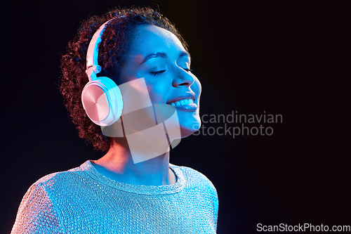 Image of woman in headphones listening to music and dancing