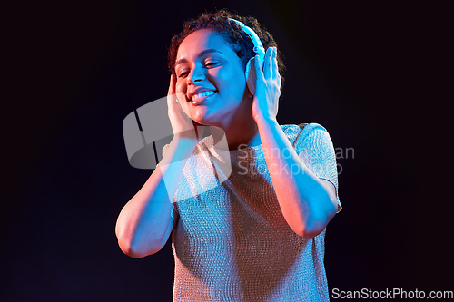 Image of woman in headphones listening to music and dancing