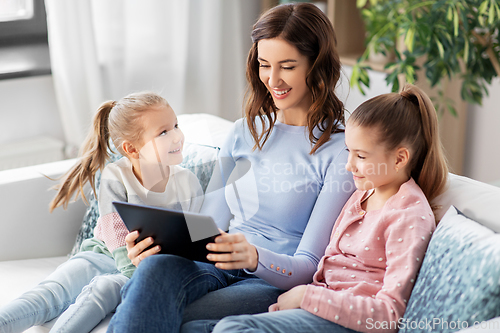 Image of happy mother and daughters with tablet pc at home