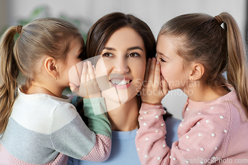 Image of happy mother and daughters gossiping at home