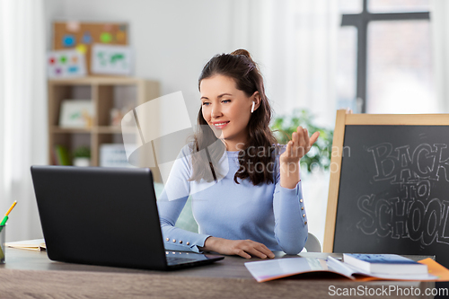 Image of teacher with laptop having online class at home