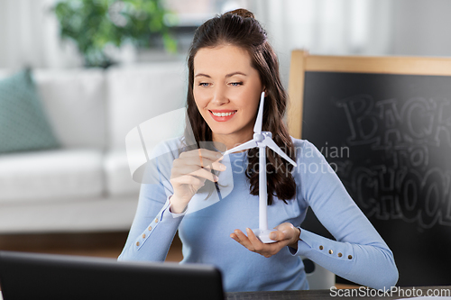 Image of teacher with laptop and windmill has online class