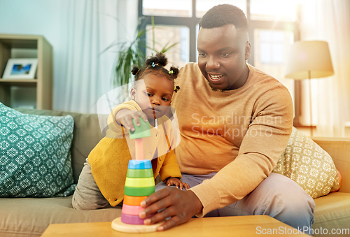 Image of african family playing with baby daughter at home