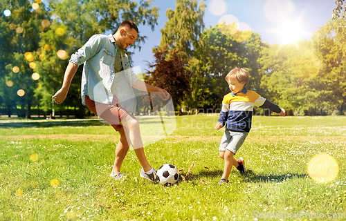 Image of father with little son playing soccer at park