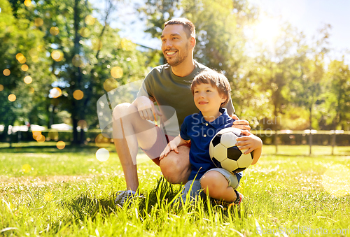 Image of father and little son with soccer ball at park