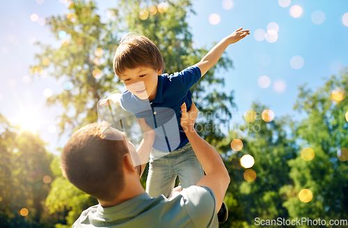 Image of happy father with son playing in summer park