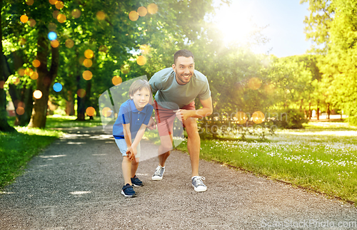 Image of happy father and son compete in running at park