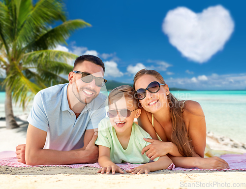 Image of happy family lying over tropical beach background