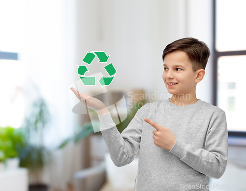 Image of smiling boy showing green recycling sign