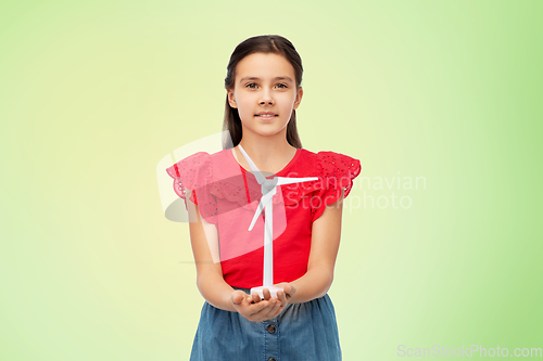 Image of smiling girl with toy wind turbine over green