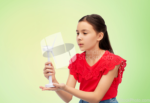 Image of smiling girl with toy wind turbine over green