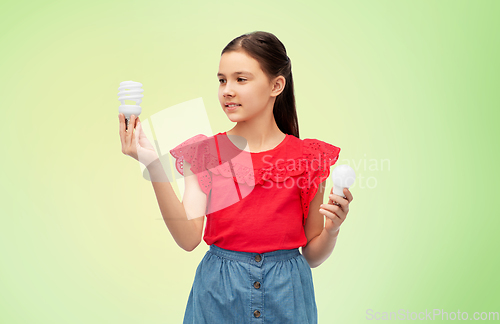 Image of smiling girl comparing different light bulbs