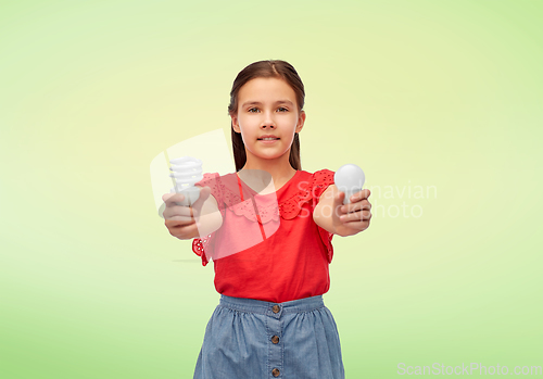 Image of smiling girl comparing different light bulbs