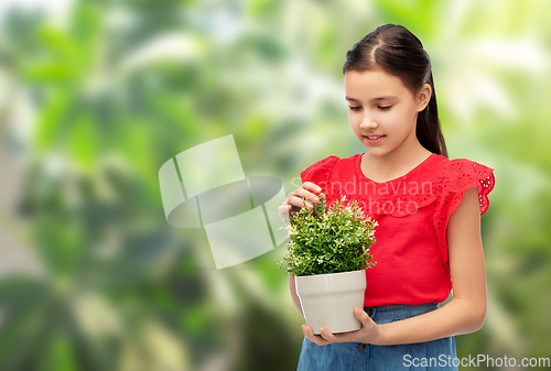 Image of happy smiling girl holding green flower in pot