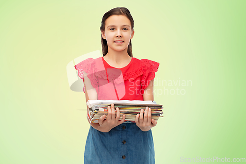 Image of smiling girl with magazines sorting paper waste