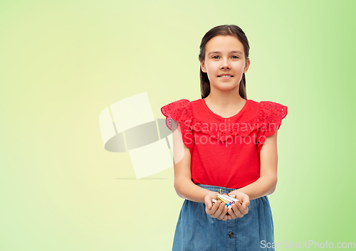 Image of smiling girl holding pile of alkaline batteries