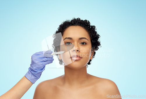 Image of african american woman and hand with scalpel knife