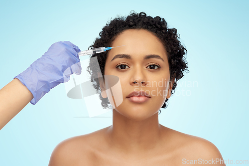 Image of face of african woman and hand with syringe