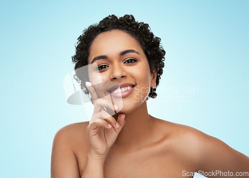 Image of young african american woman with moisturizer