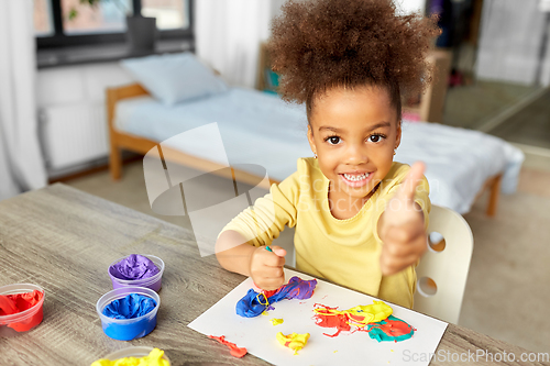 Image of little girl with modeling clay playing at home