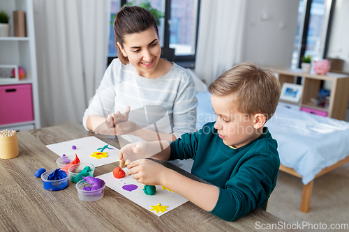 Image of mother and son playing with modeling clay at home