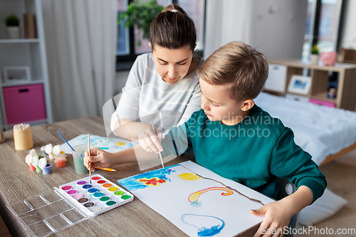 Image of mother and son with colors drawing at home