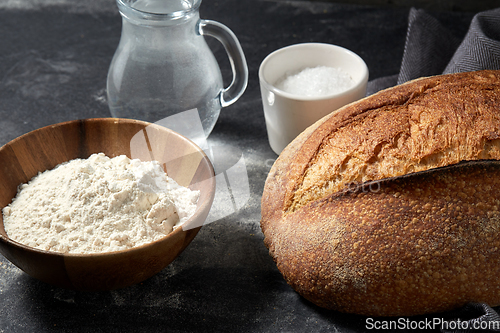 Image of bread, wheat flour, salt and water in glass jug