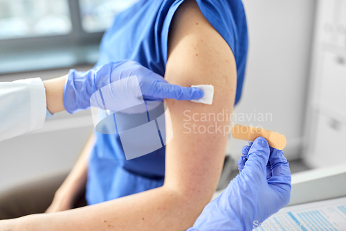 Image of doctor attaching patch to medical worker