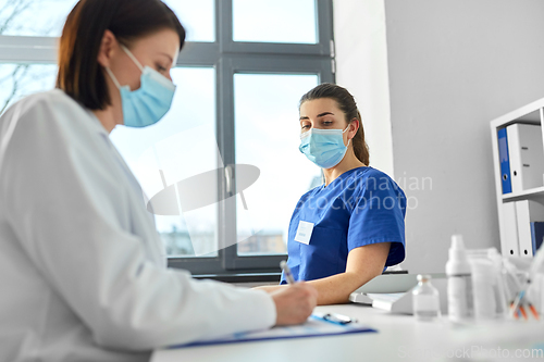 Image of doctor with clipboard and nurse at hospital